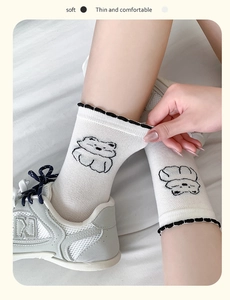 Close-up of thin mesh cotton socks with black bear pattern and wavy elastic cuffs