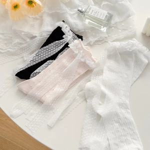 Detailed view of lace trim mesh socks with polka dot texture and ruffle edges
