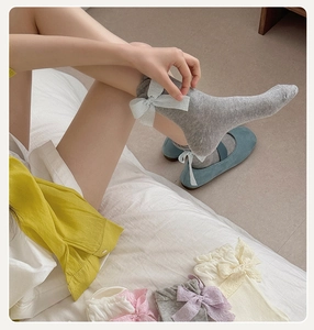 Close-up of lolita mesh socks featuring elegant silk ribbons and ruffled cuffs