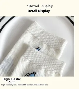 Detail shot of white socks with blue bear embroidery and high-elastic ribbed cuff