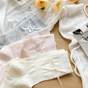Detail of sweet Lolita mid-calf socks with ribbon bows, buttons and lace edges