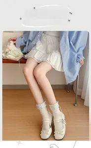 Detail of white mid-calf socks with blue plaid cuffs and bow design in ballet style