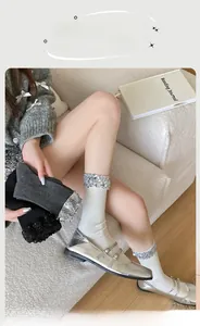 Detailed close-up of glittery ankle socks in white grey and black with silver sequins