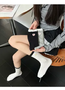 Detailed embroidery of heart and bow patterns on ribbed cotton crew socks for women