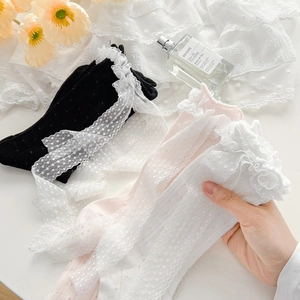 Detailed view of women's lace ruffle socks in black, pink, and white with dot patterns