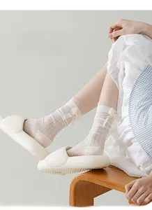 Gros plan de chaussettes en maille crème avec bordure en dentelle et nœud