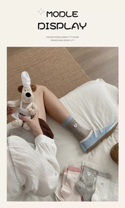 Detail of embroidered white bow on rib-knit cotton crew socks with college style design