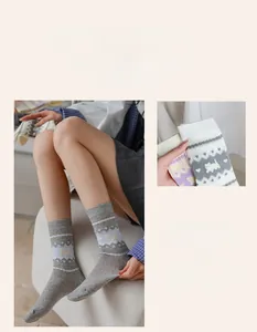 Detail of grey mesh mid-calf socks with cat jacquard pattern and ribbed cuffs