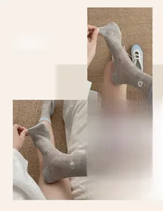 Detailed macro view showing the elastic ribbed texture and blue bow embroidery on the socks