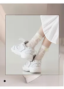 Détail de chaussettes blanches en maille avec nœuds en dentelle et texture élastique