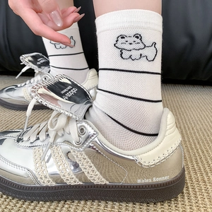 White crew socks with West Highland Terrier embroidery and striped cuffs worn with sneakers