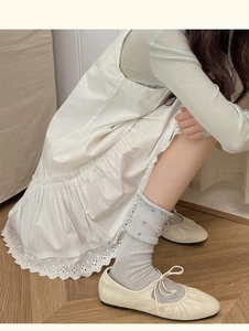 Nahaufnahme von Ballerinas mit gepunkteten Socken und gerüschtem Baumwollsaum