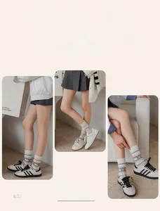 Detail view of cotton socks with heart patterns and ribbed cuffs in beige and purple