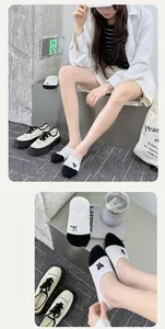 Close-up of black and white low-cut invisible cotton socks with bow embroidery detail