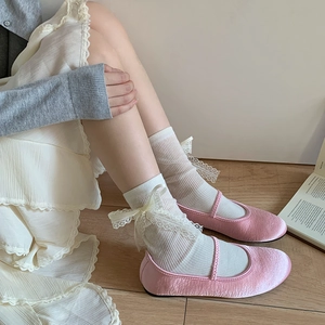 Pink satin Mary Jane flats paired with white lace bow crew socks in a ballet style