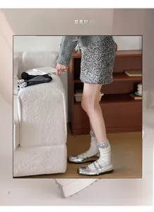 Detail of high elasticity white knit socks with sparkling silver sequin cuffs and Mary Jane shoes