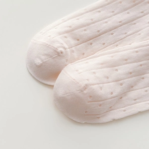 Close-up of pink pointelle knit socks featuring breathable hollow mesh and fine stitching