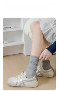 Détail de chaussettes grises en coton respirant avec des baskets blanches rétro chic