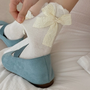 Mesh mid-tube socks with large cream bow detail paired with Mary Jane shoes