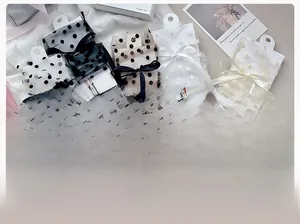 Détail de chaussettes en tulle transparent à pois et décoration de nœud doux
