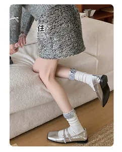 Detail of silver patent leather Mary Jane shoes with sparkling rhinestone gaiter socks