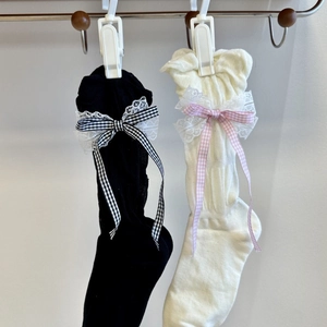 Detailed close-up of lace edge with bow ribbons on summer Lolita style socks