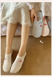 Detail of cable knit low cut socks with cute strawberry embroidery and mini bows