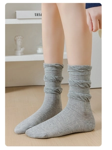 Détail de chaussettes en maille gris clair avec texture en spirale et bordure volantée