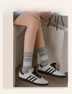 Detailed knit pattern on gray mid-calf socks with white geometric animal motifs