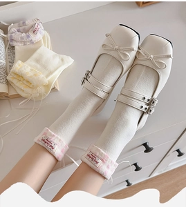 Close-up of beige Mary Jane flats with delicate bow and double metallic straps