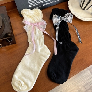 Detailed view of Lolita style mid-calf socks with lace edges and plaid ribbon bows