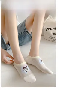 Detail of breathable mesh low-cut socks with cute cartoon dog pattern on light beige fabric
