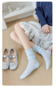 Détail de chaussettes bleues à mailles ajourées avec texture torsadée et motif respirant
