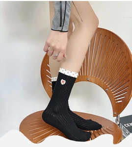 Detail of cotton socks with white polka dot cuffs and red heart embroidery on a model