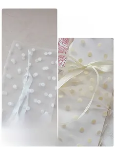 Détail de chaussettes en tulle à pois avec nœuds en soie et poignets élastiques