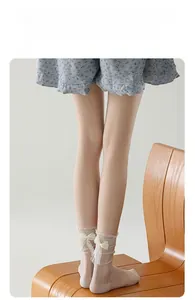 Gros plan de chaussettes en résille rose avec bordure en dentelle et nœud en satin beige