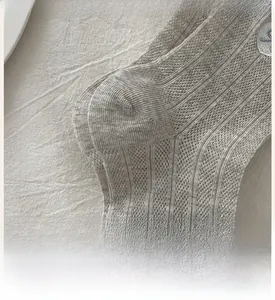 Macro view of gray ribbed cotton socks featuring reinforced heel and embroidered patterns