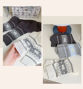 Detail of cute knitted dog pattern socks with elastic cuffs in various colors