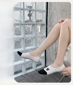 Detail of low-cut cotton blend invisible socks with black bow embroidery and color contrast