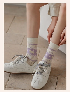 Detail of white and purple mesh socks with cat patterns paired with retro sneakers