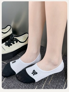 Detailed view of low-cut cotton socks with bow embroidery and color-block design