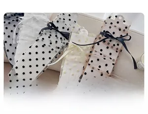 Détail de chaussettes en tulle à pois avec des nœuds décoratifs en soie sur un tissu doux