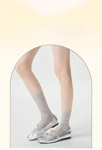 Close-up of light grey hollow mesh lace socks with wavy texture and cotton fabric