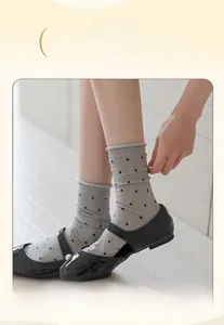 Detail showing elastic wide cuff on gray polka dot crew socks with high stretch fabric