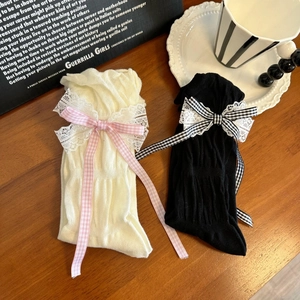 Detail of Lolita style mid-calf socks with lace trim and plaid bow ribbon accents