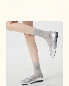 Close-up of light gray mesh lace socks paired with silver ballet flats for a sweet style