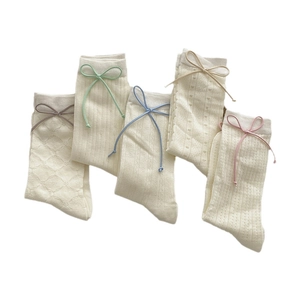 Cinq paires de chaussettes blanches en maille avec motifs dentelle et nœuds en cuir colorés