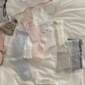 Morandi-Farben Polka-Dot-Socken mit Rüschenbündchen auf weichem weißem Hintergrund