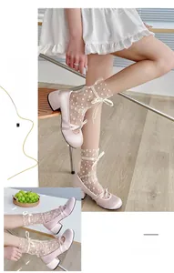 Détail de chaussures Mary Jane en satin rose avec chaussettes résille à pois et nœud