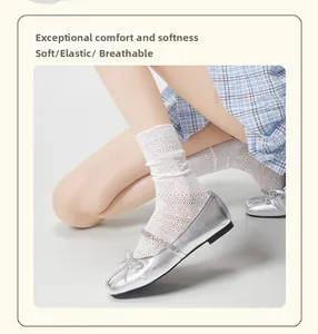 Close-up of white floral lace mid-calf socks paired with silver metallic bow flats